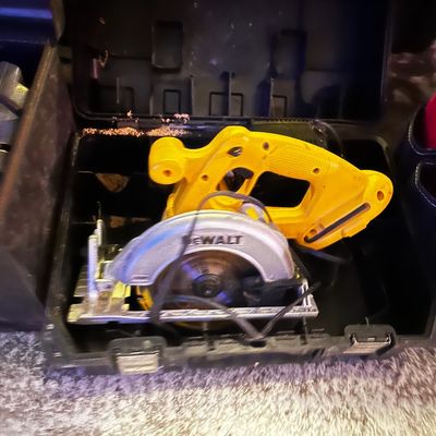Sale Photo Thumbnail #34: DeWalt corded circular saw resting inside its black hard plastic carrying case.
