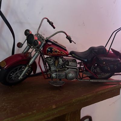 Sale Photo Thumbnail #157: Vintage-style miniature red motorcycle figurine with flame graphics, sissy bar, and saddlebags.