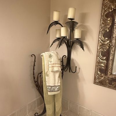 Sale Photo Thumbnail #231: Palm tree motif metal wall sconce with pillar candle holders, paired with a matching wrought iron towel stand.