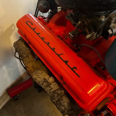 Sale Photo Thumbnail #50: Classic Chevrolet V8 engine block painted bright orange with scripted valve covers, mounted on an engine stand.