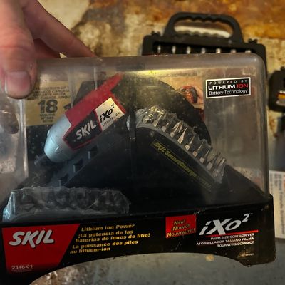 Sale Photo Thumbnail #148: Skil iXo2 palm-size cordless screwdriver set with lithium-ion charger base and driver bits, in original clear plastic case.