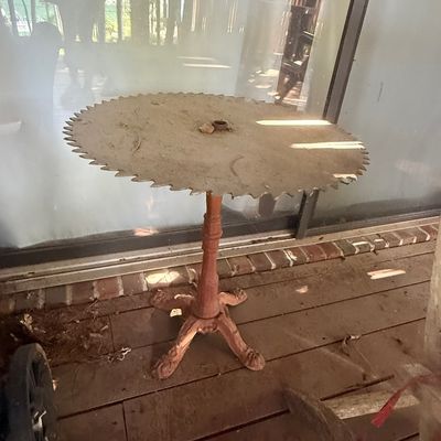 Sale Photo Thumbnail #226: Rustic accent table repurposed with a large circular saw blade top mounted on a cast iron pedestal base.