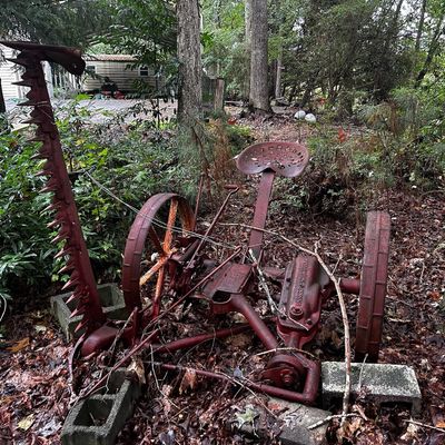 Sale Photo Thumbnail #118: Vintage McCormick-Deering horse-drawn sickle mower with red painted finish and iron wheels, displaying weathered patina.