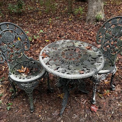 Sale Photo Thumbnail #119: Three-piece cast aluminum bistro set featuring a round table and two matching chairs with ornate rose motifs.