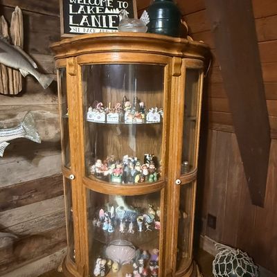 Sale Photo Thumbnail #238: Traditional oak curio display cabinet with curved glass panels, claw feet, and interior shelving filled with collectibles.