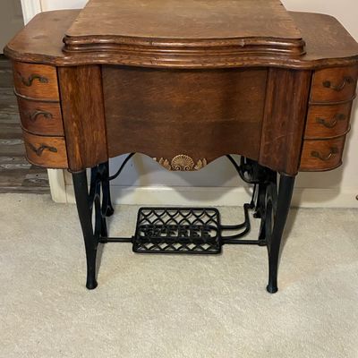 Sale Photo Thumbnail #204: Antique Free Sewing Machine Co. treadle cabinet in quarter-sawn oak with cast iron base, side drawers, and shell carved accent.
