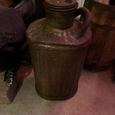Sale Photo Thumbnail #27: Vintage rust-patinated metal kerosene or liquid fuel jug featuring a side handle and screw-top spout.