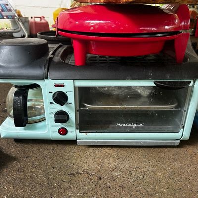Sale Photo Thumbnail #143: Aqua Nostalgia 3-in-1 breakfast station featuring a coffee maker, toaster oven, and top griddle with a red pizza maker resting on top.