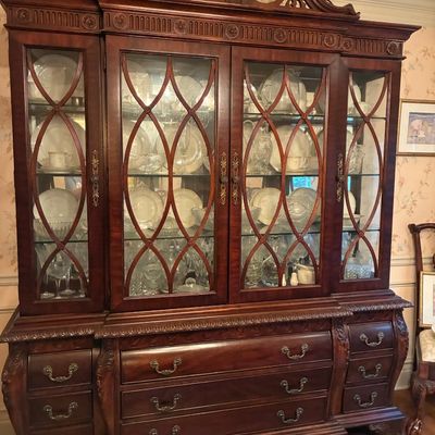 Sale Photo Thumbnail #179: Traditional Chippendale-style mahogany china cabinet featuring a broken-pediment top, intricate door mullions, and brass bail handles.