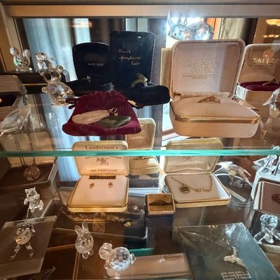 Sale Photo Thumbnail #20: Display case featuring a collection of fine jewelry and crystal figurines, including Black Hills Gold pieces, Landstrom's box sets, EFFY sterling silver necklaces, and swarovski crystal animal miniatures.