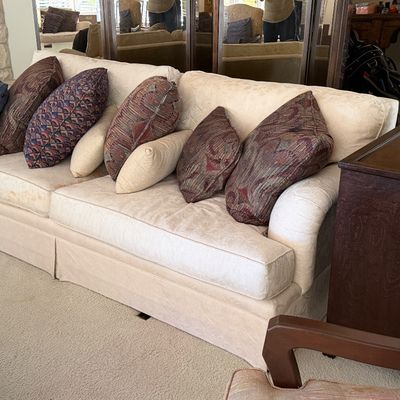 Sale Photo Thumbnail #8: Large cream damask-patterned sofa styled with a skirted base and various colorful throw pillows.