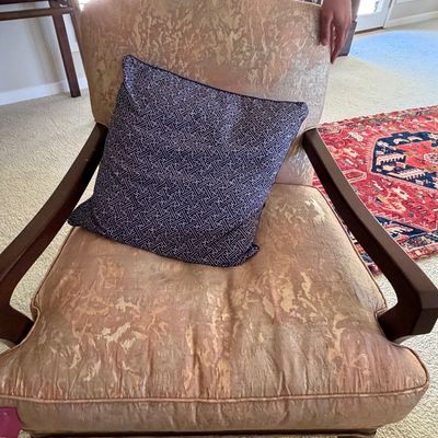 Sale Photo Thumbnail #10: Vintage upholstered armchair with dark wooden arms and legs, paired with a patterned navy blue accent pillow.