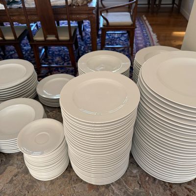 Sale Photo Thumbnail #2: Large collection of stacked white ceramic dinnerware, including various sizes of plates, bowls, and saucers.