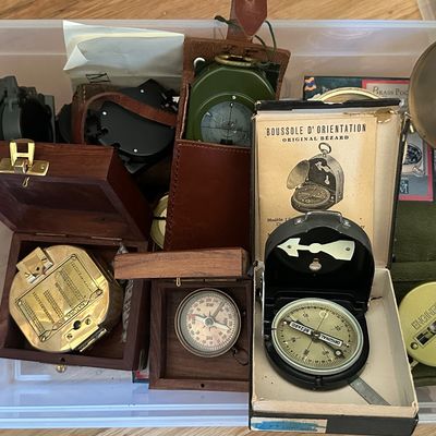 Sale Photo Thumbnail #44: collection of vintage compasses, including brass surveying compasses in wooden boxes, military-style pocket compasses, and an Original Bézard orientation compass in its box.