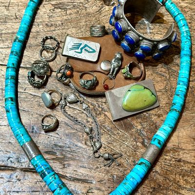 Sale Photo Thumbnail #96: Collection of vintage Southwestern and sterling silver jewelry, featuring a turquoise disc bead necklace, a large lapis lazuli cuff bracelet, several carved silver rings, and money clips.