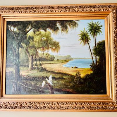 Framed oil painting depicting a Florida Highwaymen-style tropical wetland landscape with palm trees, moss-draped oaks, and white egrets...