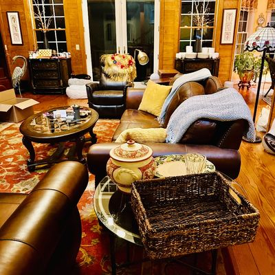Sale Photo Thumbnail #97: Rustic living room setup featuring brown leather sofas, an oval glass-top coffee table, glass side table with woven basket, and various home decor accents.