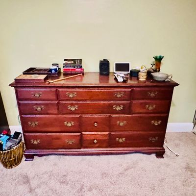 Sale Photo Thumbnail #85: Traditional wooden double dresser featuring brass hardware and bracket feet, topped with various decor items.