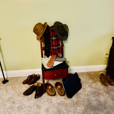 Sale Photo Thumbnail #82: Collection of men's accessories including leather dress shoes, loafers, fedoras, scarves, and a briefcase displayed on and around a wooden chair.