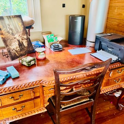Sale Photo Thumbnail #68: Ornate carved wooden executive desk with matching ball-and-claw foot chair, holding various home office supplies, electronics, and small decor items.