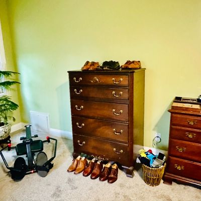 Sale Photo Thumbnail #86: Traditional dark wood highboy dresser and matching nightstand with brass batwing hardware, displaying men's leather dress shoes and a rowing machine nearby.