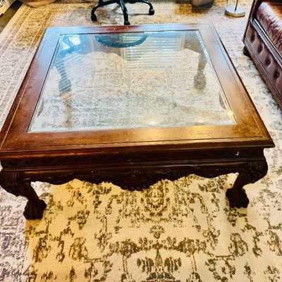 Sale Photo Thumbnail #51: Traditional square wooden coffee table featuring a glass insert top and carved ball-and-claw feet.