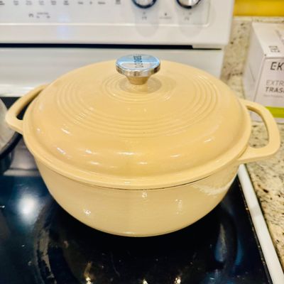 Sale Photo Thumbnail #26: Lodge cream-colored enameled cast iron Dutch oven with lid and stainless steel knob.