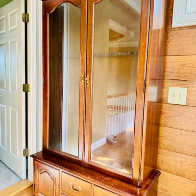 Sale Photo Thumbnail #64: Traditional wooden hutch cabinet featuring a glass-front display top section above a base with drawers and cabinet doors.