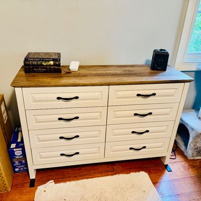 Modern farmhouse style eight-drawer dresser featuring a white painted base, dark metal handles, and a natural wood-grain top.