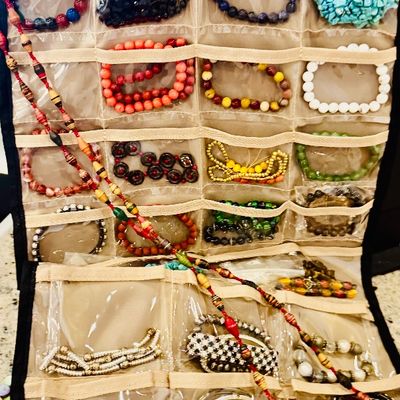 Sale Photo Thumbnail #27: Hanging clear-pocket jewelry organizer filled with an extensive collection of colorful fashion necklaces, beaded bracelets, and bangles.