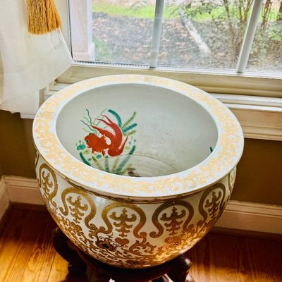 Chinese porcelain koi fish basin planter featuring gold scrolling filigree on the exterior and painted goldfish on the interior, set on a...