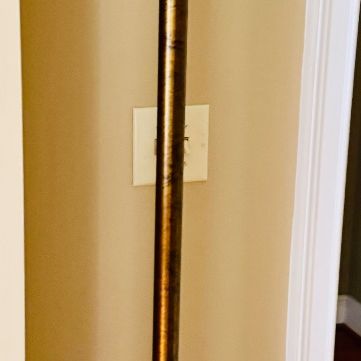 Traditional metal torchiere floor lamp with a distressed bronze finish and a white frosted glass shade.