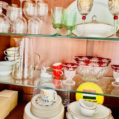 Sale Photo Thumbnail #78: Wooden display hutch filled with assorted glassware and china, including ruby-flashed cut crystal, gold-embellished stemware, and green pressed glass goblets.