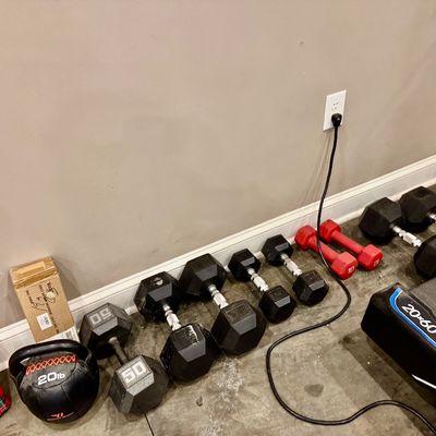 Sale Photo Thumbnail #38: Collection of home gym equipment including rubber-coated hex dumbbells in various weights, a 20 lb medicine ball, red neoprene hand weights, and a ProForm treadmill.