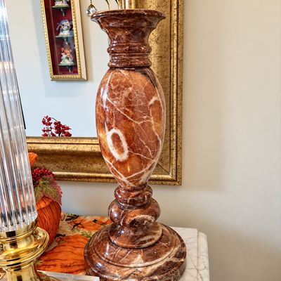 Sale Photo Thumbnail #82: Polished brown and white marbled onyx candlestick holder with a tiered base and baluster-style body.