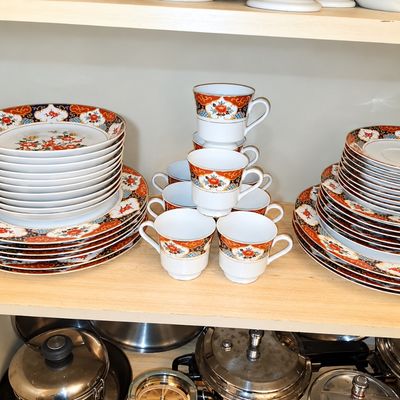 Sale Photo Thumbnail #98: Vintage Imari-style porcelain dinnerware set featuring stacked plates, saucers, and teacups with intricate floral and geometric patterns.