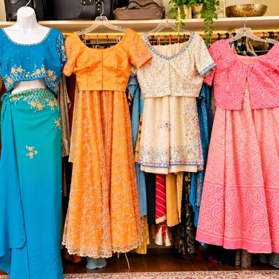 Sale Photo Thumbnail #63: Collection of colorful, embellished traditional South Asian garments including lehenga choli sets and sarees, displayed on mannequins and hangers.