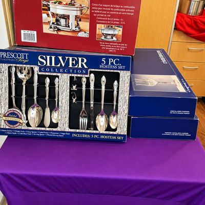 Sale Photo Thumbnail #89: Boxed Prescott Silver Forge 5-piece hostess set and flatware collection, alongside boxed Cristallerie d'Arques glassware and a stainless steel chafing dish.