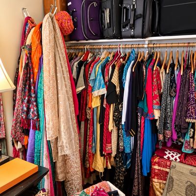 Sale Photo Thumbnail #85: Closet filled with colorful Indian traditional attire, scarves, and accessories, along with a row of rolling suitcases stored on the top shelf.