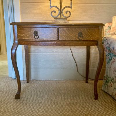 Vintage oak writing desk or side table featuring cabriole legs and two drawers with lion head ring pulls, 

