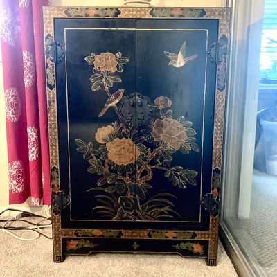 Asian-style hand-painted black lacquer two-door cabinet featuring floral motifs and birds with decorative hardware.