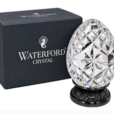 Sale Photo Thumbnail #25: Waterford clear cut crystal egg figurine with starburst patterns, displayed on a dark base with the original box.