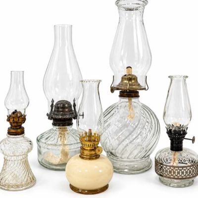 Sale Photo Thumbnail #16: Collection of five vintage clear and opaque glass oil lamps featuring metal burners, clear glass chimneys, and varied swirl-patterned and detailed bases.