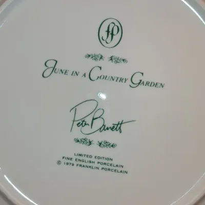 Sale Photo Thumbnail #651: Backside maker's mark on a 'June in a Country Garden' limited edition fine English porcelain plate by Peter Barrett for Franklin Porcelain, dated 1979.