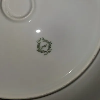 Sale Photo Thumbnail #541: Underside of an O. & E.G. Royal Austria porcelain dish showing the maker's mark with a green laurel wreath.