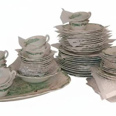 Sale Photo Thumbnail #705: Large vintage green transferware dinnerware set, including stacks of plates, bowls, teacups, and a serving platter.