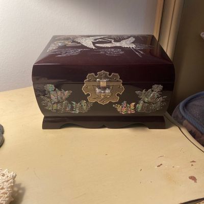 Korean black lacquer jewelry box featuring mother-of-pearl inlay of cranes and floral motifs with decorative brass hardware.