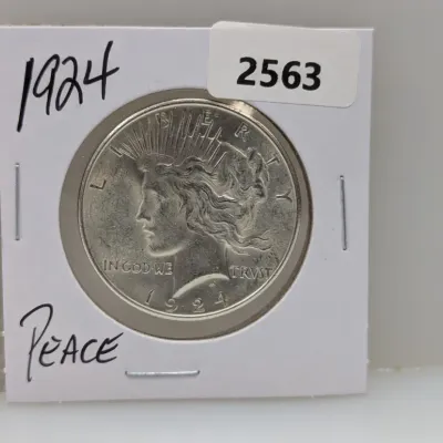 Sale Photo Thumbnail #888: 1924 Peace silver dollar housed in a protective cardboard flip holder.