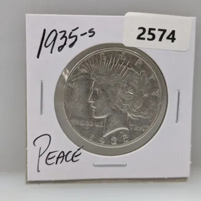 Sale Photo Thumbnail #899: 1935-S Peace silver dollar coin mounted in a cardboard cardboard 2x2 flip holder.