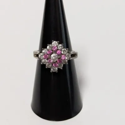 Sale Photo Thumbnail #807: Vintage silver-tone cluster ring featuring a central round stone encircled by pink and clear accent stones in a diamond pattern.